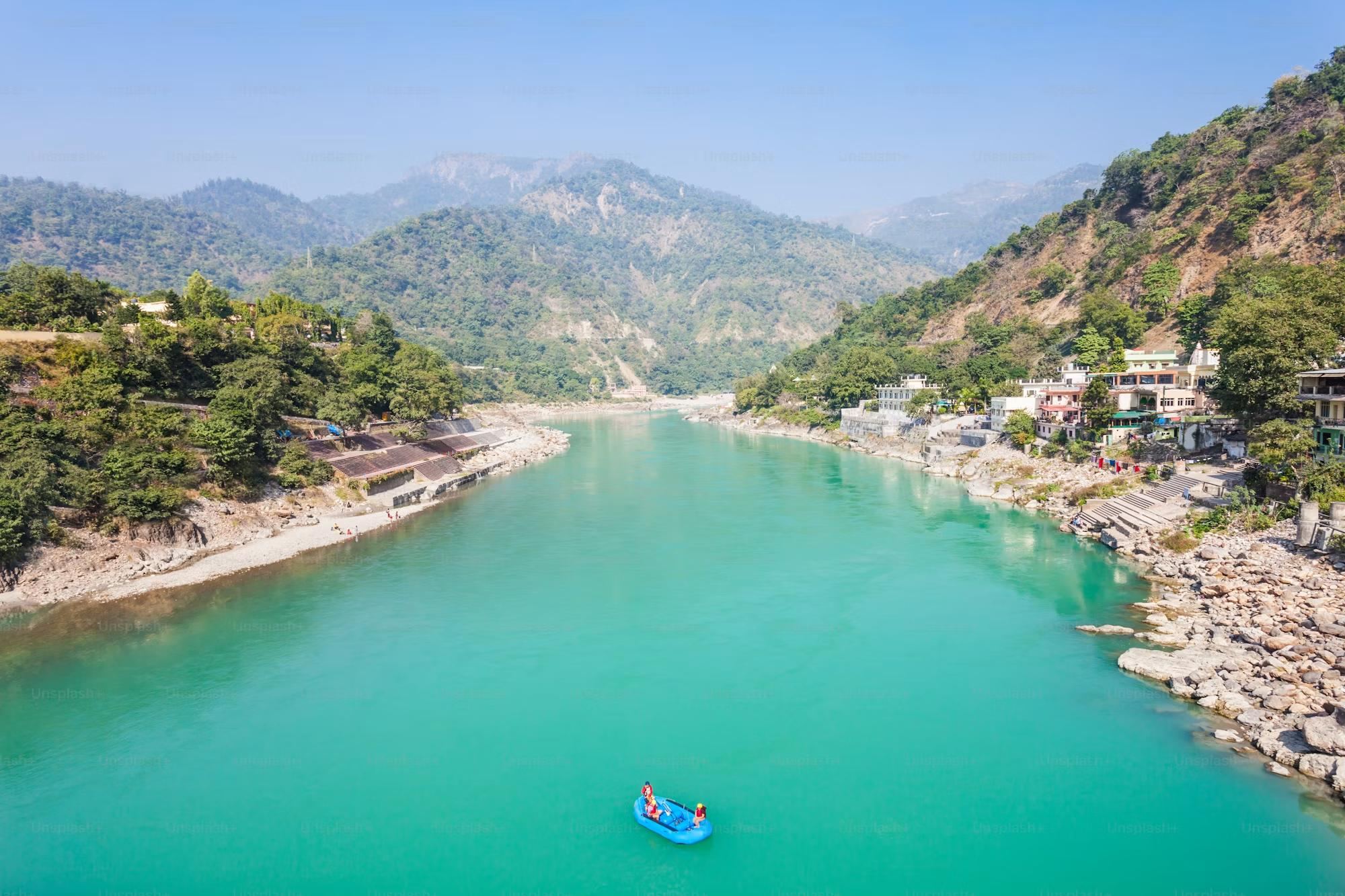 The Ganga running turquoise between forested hills at Rishikesh