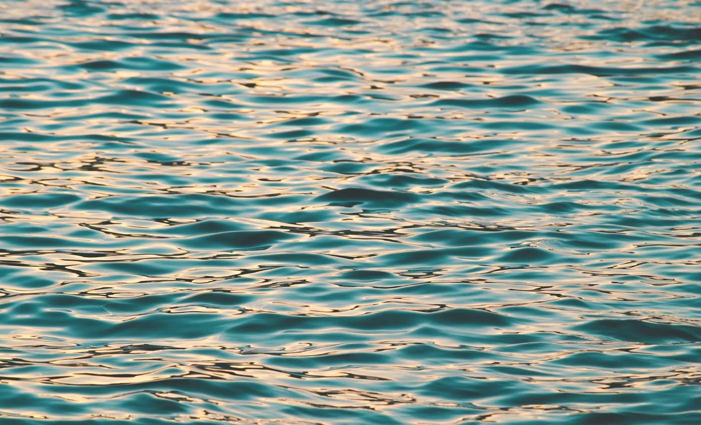 Late sun breaking into gold across moving river water